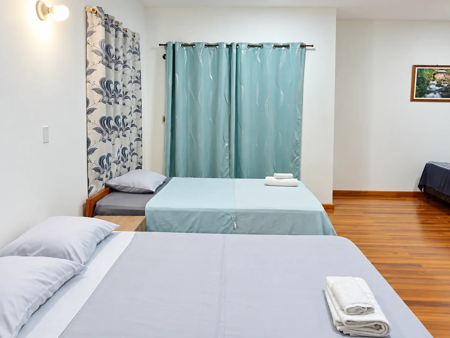 Habitación amplia con varias camas y piso de madera