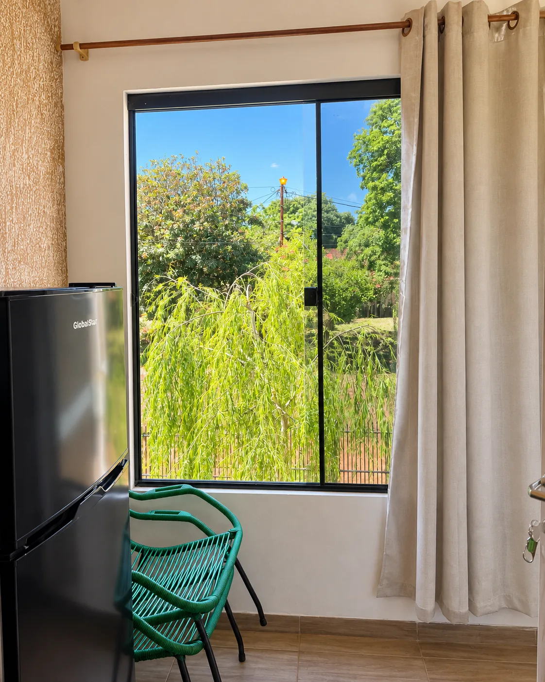 Ventana de la segunda habitación con vista a árboles y vegetación